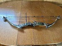 Side view of the full compound bow showing overall design and camouflage finish.
