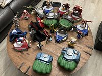 Full overview of the Playmation set showing Hulk gloves, character figures including Iron Man, Captain America, Thor, Hulk and others, bases and additional accessories on wooden table.