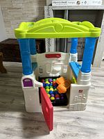 View of the Step2 kids ball pit with colorful plastic balls inside and surrounding furniture.
