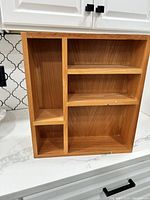 Small wooden bookshelf with multiple compartments for organizing small kids books.