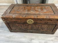 Front and top angled view showing detailed carved ships and brass lock