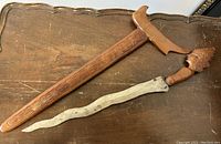 Top-down view of the kris dagger and wooden sheath showing length, blade shape and handle detail.