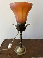 Full view of the lamp showing the metal base and orange Aurene glass shade with floriform metal support.