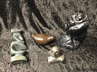 Four assorted Inuit folk art sculptures on black textured fabric background