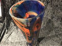 Photo showing angled view into the flared top of the vase, highlighting the swirl pattern and rich colours