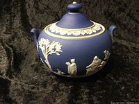 Side view of the blue jasperware Wedgwood bowl showing handles and white classical figures relief.