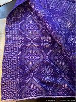 Full view of the purple woven wool blanket showing the floral and diamond pattern textile design