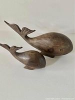 Mother and calf whale hand carved from dense dark ironwood wood, side angle showing smooth finish and wood grain