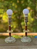 Front view showing pair of small MCM teak and vintage glass lamps with round bubble textured bases and layered glass discs