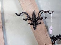 Side angle showing the curved double arms and the mounting plate of the cast iron rack.