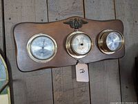 Full view of Springfield wooden panel with three weather instrument dials: thermometer, barometer, and humidity meter, including eagle emblem