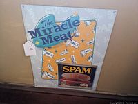 Front view of the metal sign showing 'The Miracle Meat' text, starburst design, and Spam images
