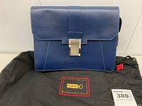 Front view of electric blue leather wristlet handbag on dust bag