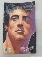 Front cover photo showing painted portrait of Sylvester Stallone with title and issue date visible, some damage and creases present.