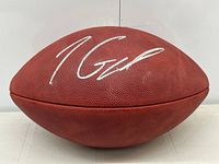 Front full view of football showing silver autograph across panel