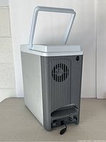 Full profile view of Koolatron electric cooler with handle raised showing the fan vent and cord.