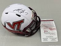 Photo of the signed Virginia Tech miniature football helmet with visible Michael Vick autograph and JSA certification card included in the frame.