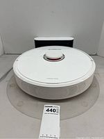 Front view of the white Roborock S6 on its charging dock with identification tag