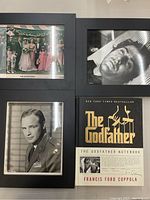 Framed photos and book laid out, showing full front of items