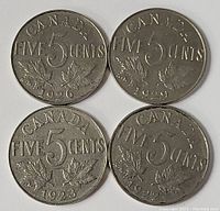 Four Canadian five-cent coins dated 1929, 1926, 1923, and 1922 showing reverse side with denomination and maple leaf design.