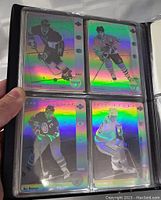 Four 1991 McDonald's NHL hologram hockey cards shown in protective sleeves, featuring players Wayne Gretzky, Ray Bourque, Cam Neely, and Patrick Roy.