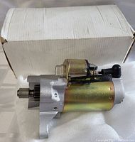 Side view of the starter motor showing the output shaft and solenoid against a white box background.