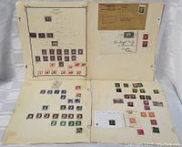 Four album pages with Canadian stamps and two envelopes attached.