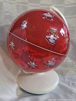 Front view of the red Mars globe showing planetary surface and mission icons on white stand