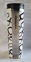 Front view of Starbucks travel mug showing glasses-themed print and clear strip with Starbucks branding
