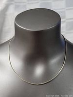 Full view of the sterling silver necklace displayed on a gray mannequin bust showing the length and design.