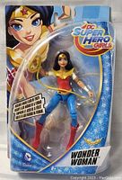 Front view of Wonder Woman action figure in blue and red outfit with gold accessories, sealed in original packaging.