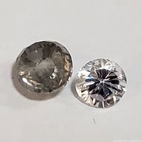 Two round cut diamonds displayed on white background
