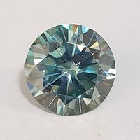 Top view of the round-cut blue moissanite gemstone showing faceting and clarity.