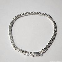 Full view of the silver bracelet laid flat showing the entire 7.5 inch length and lobster clasp.