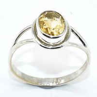 Front view showing oval citrine with faceted cut set in sterling silver ring band.