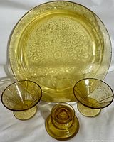 Full set showing large amber cake plate, two fruit bowls, and one candle stick in Federal Depression glass Madrid pattern.