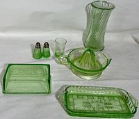 Front view of the full set: reamer, tumbler, salt and pepper shakers, vase, relish tray, and butter dish topper on white background