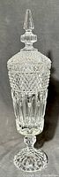 Full view of tall transparent white crystal vase with lid and obelisk handle, showing diamond overlay and fluted lower bowl.