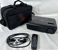 Optoma EX536 projector, remote control, power cord, and carrying bag displayed on white background.