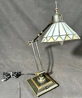 Full view of the desk lamp showing adjustable arm, metal base, power cord and stained glass shade.