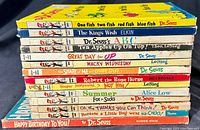 Stacked view of 13 vintage books by Dr Seuss and related authors, mostly hardcover with colorful spines