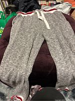 Full view of gray sweatpants laid flat showing fabric texture and waistband