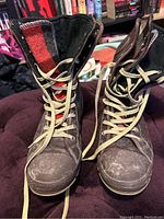 Front view of both boots standing upright with tongues pulled forward showing plaid winter liners inside.