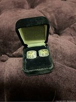 Pair of cufflinks in a black velvet presentation box showing lion rampant design