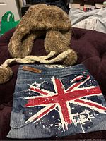 Photo showing the denim clutch with distressed British flag print and Almost Famous brand leather patch.