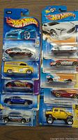 10 new Hot Wheels toy cars in original blister packaging, assorted models and colors.