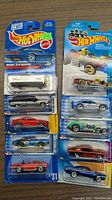 Photo of 10 new Hot Wheels cars in original unopened packaging, showing front view of each car and packaging details.