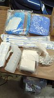 Various packaged disposable medical supplies including bags, gauze, bandages, and tubing.