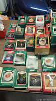 Several Hallmark Keepsake Christmas ornaments in original boxes arranged on table, showing variety of designs and packaging.