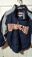 Front view of navy and gray Washington Nationals jacket with large embroidered 'Washington' lettering.